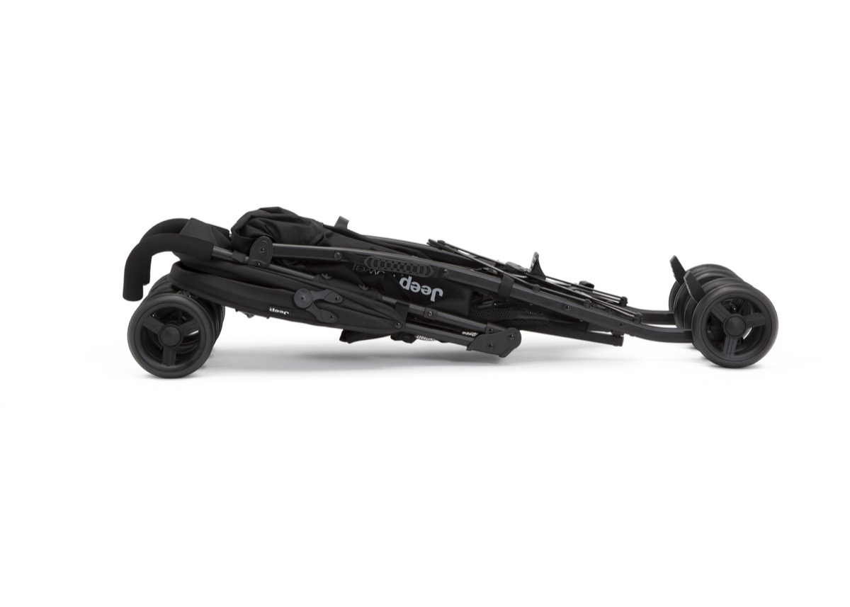 Official Delta Children product-page photo of the Jeep PowerGlyde Plus Stroller in Black (001) folded flat in its compact umbrella fold, lying on its side with the wheels and folded frame visible, against a white background